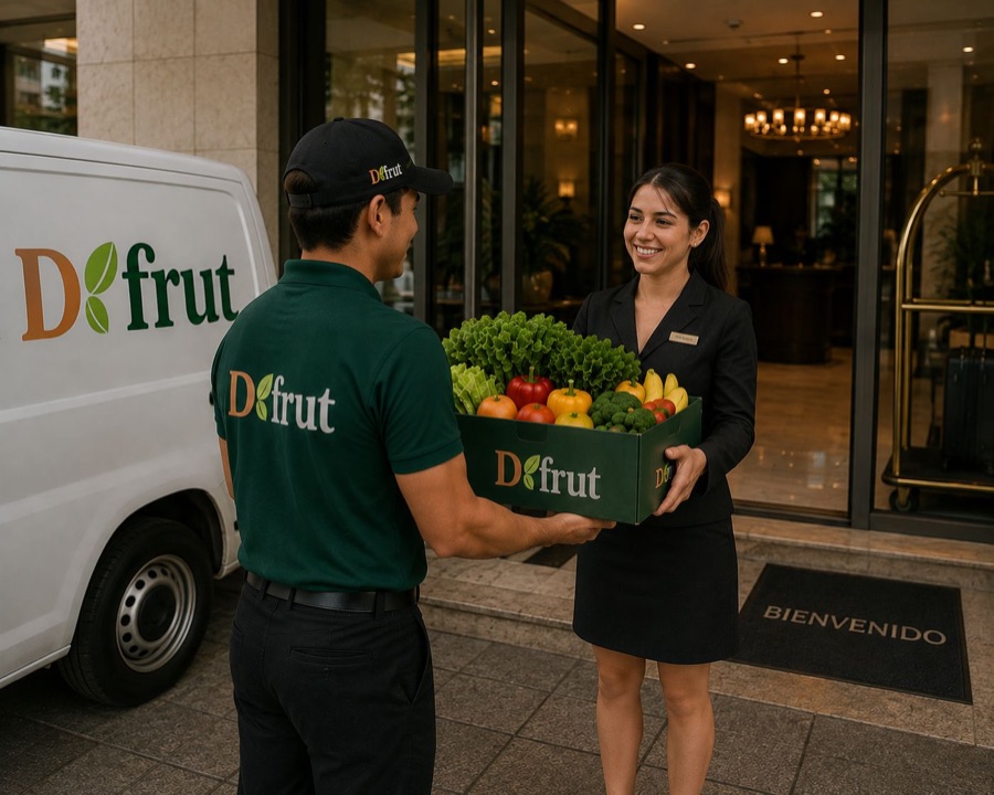 Repartidor de VERDFRUT entregando una caja de fruta y verdura en la recepción de un hotel